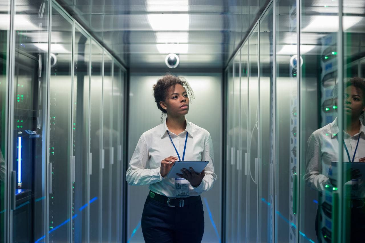 Woman checking servers in a data center.