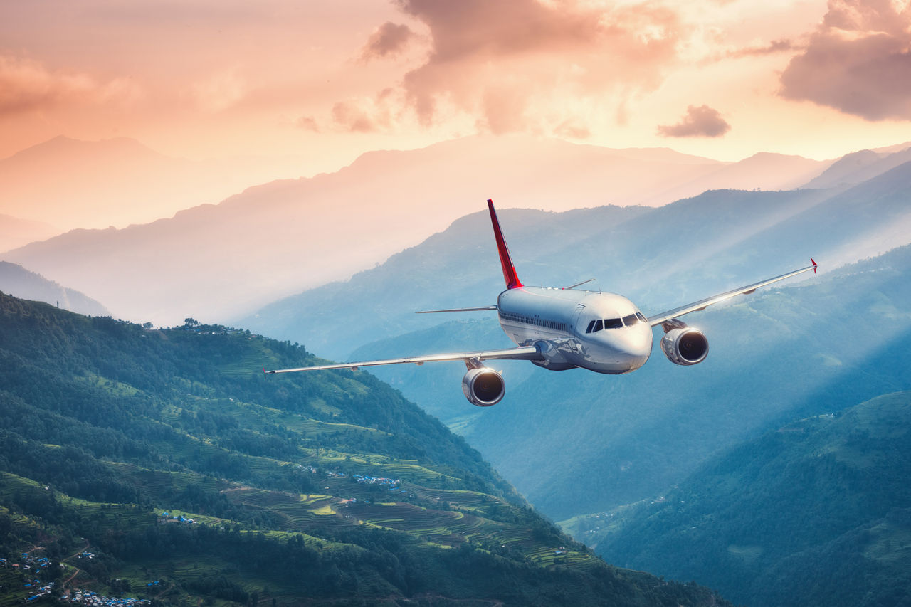 Airplane flying through mountain tops.