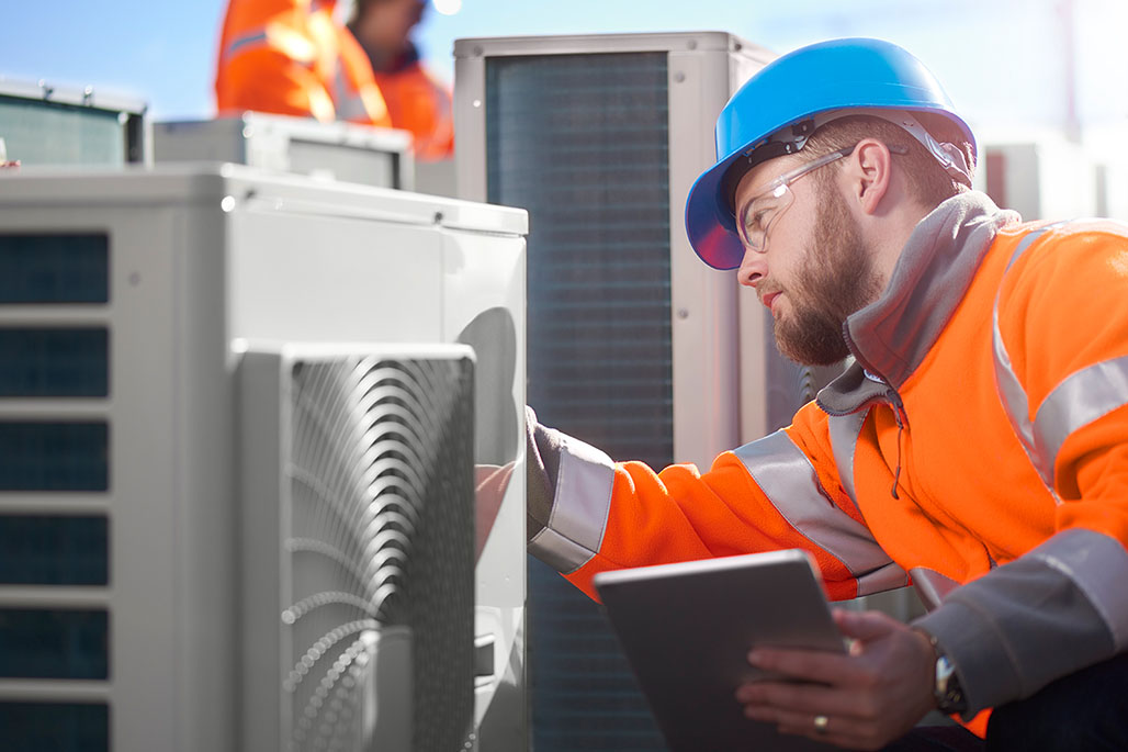 Workers assessing commercial HVAC equipment.