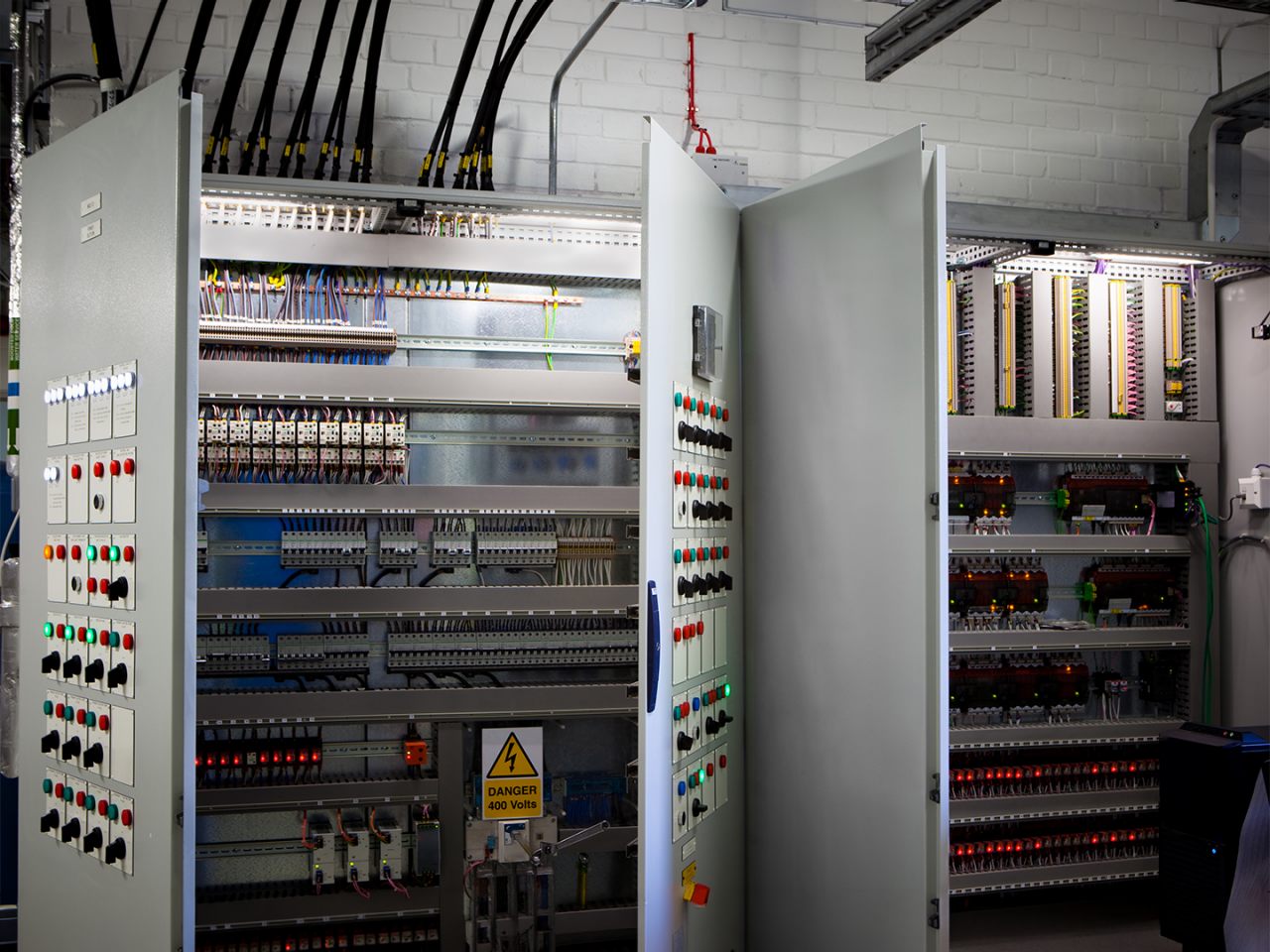 Open industrial control panels with DIN rail-mounted terminal blocks, wiring and electrical components.