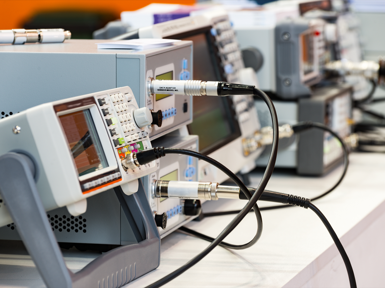 Digital test and measurement instruments connected by coaxial cables in an electronics laboratory.