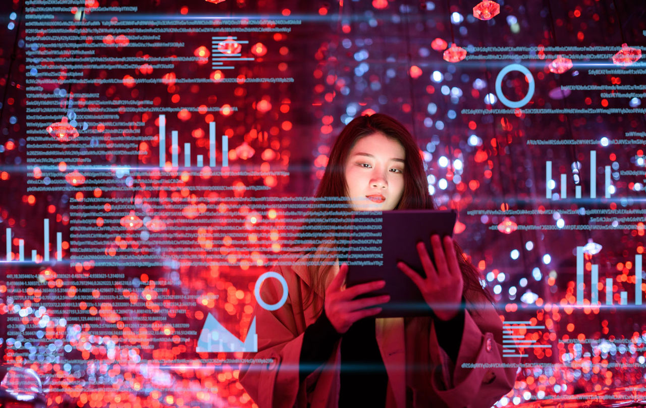 Female using a tablet with graphical representation of data.